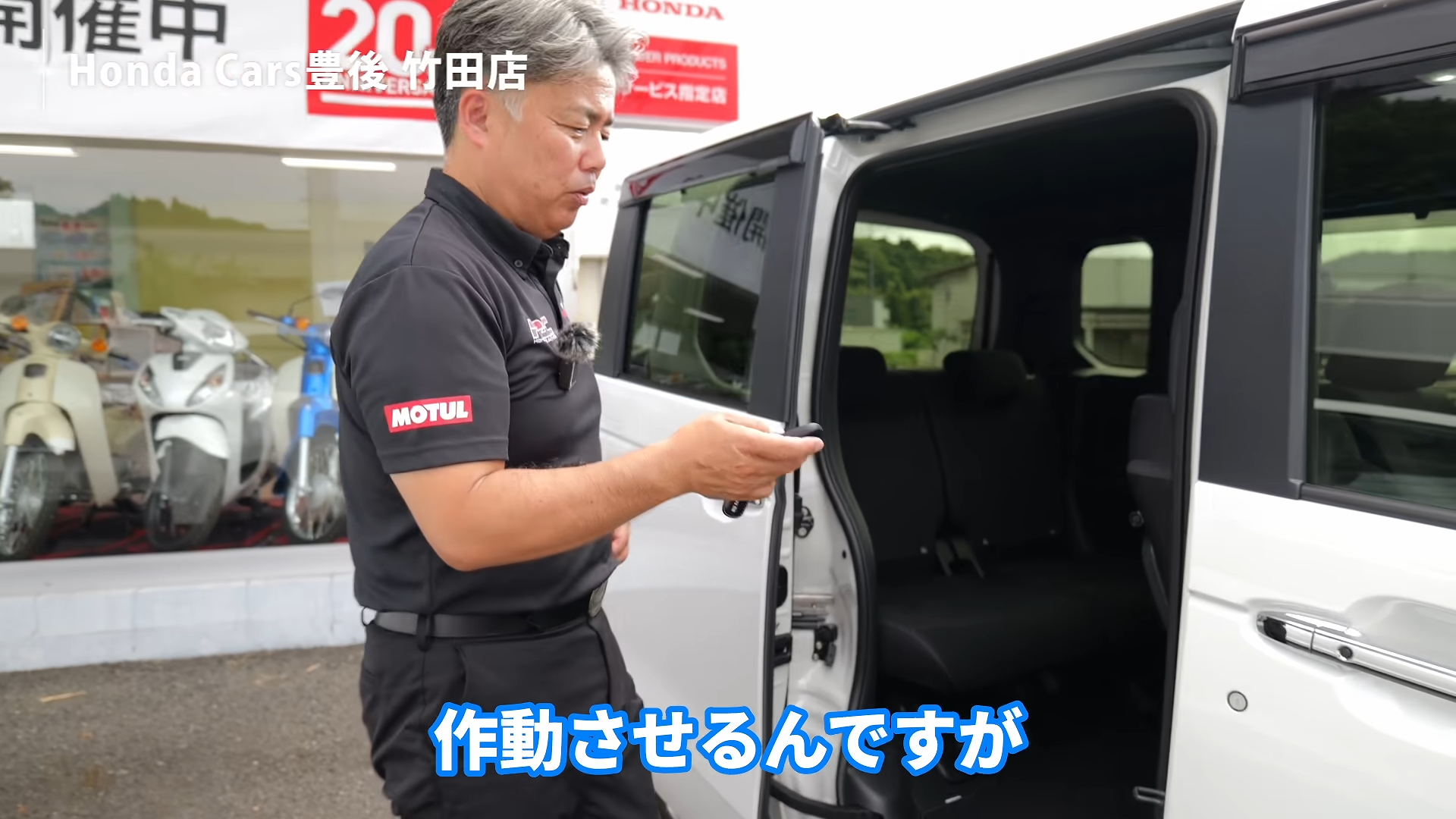 スライドドアを開けた状態で施錠スイッチを押す様子